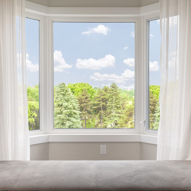 Bay,Window,With,Drapes,,Curtains,And,View,Of,Trees,Under
